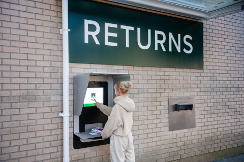 Person returning a book at the external book return Person returning a book at the external book return