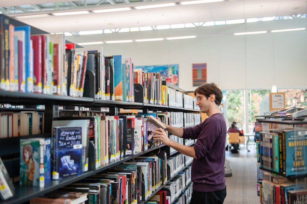 Person shelving books at Tommy Douglas