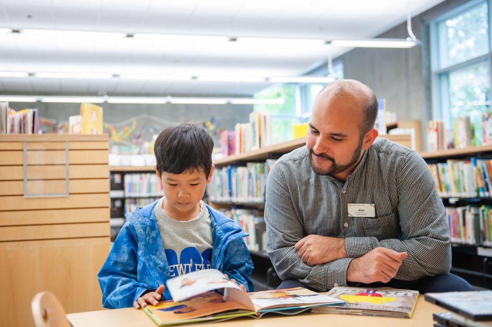 Children's librarian and child reading a book