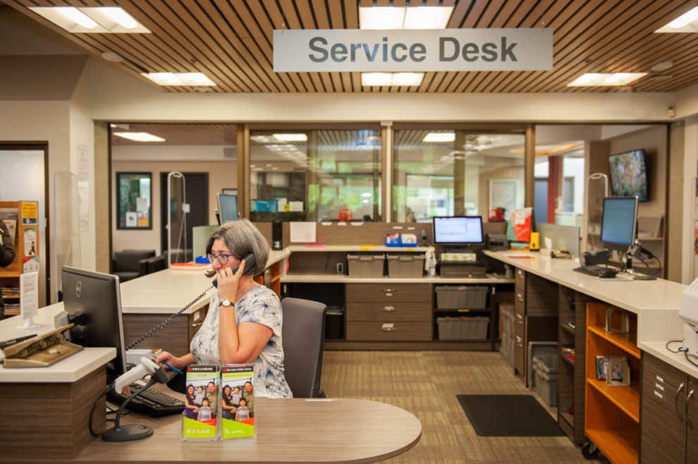 Staff on phone behind the Service Desk at Cameron Branch