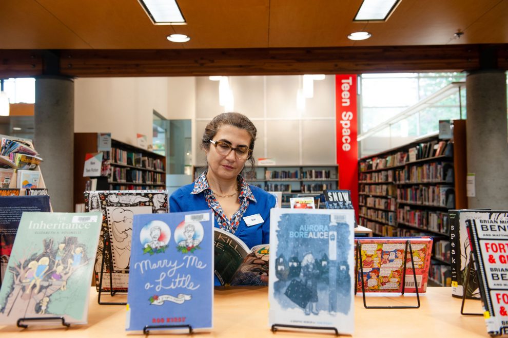 Staff looking at teen books Staff looking at teen books